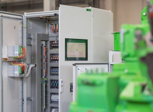 Techniker arbeitet an großem Servergestell in einem beleuchteten Datenzentrum, mit PowerUP-Logo sichtbar.