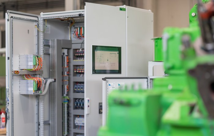 Techniker arbeitet an großem Servergestell in einem beleuchteten Datenzentrum, mit PowerUP-Logo sichtbar.